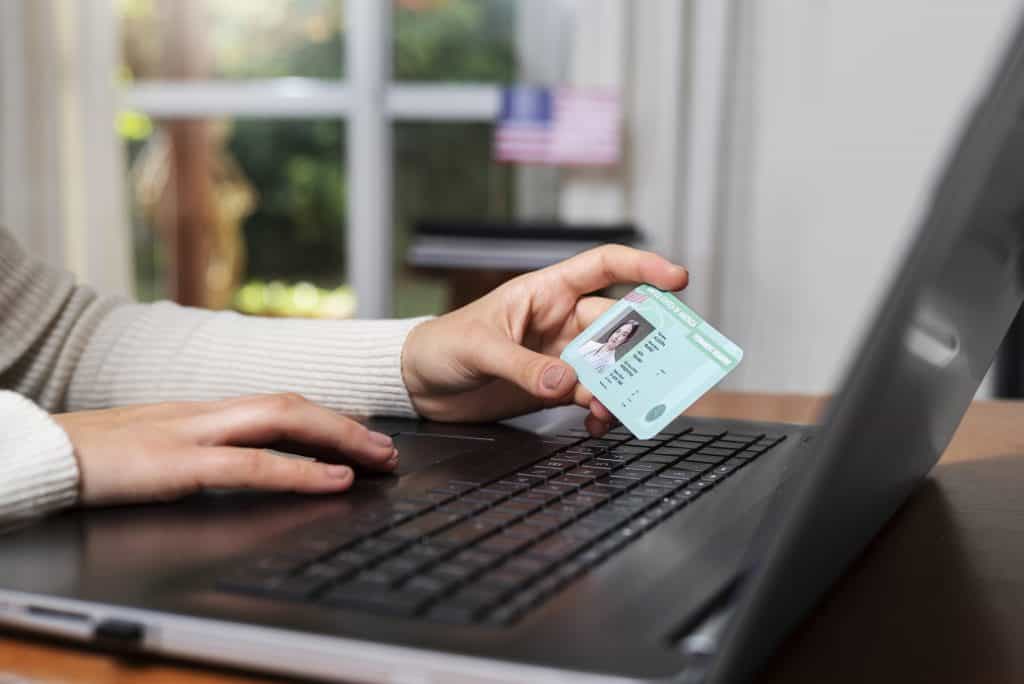 Profissional de imigração USA com cartão de residência e laptop.